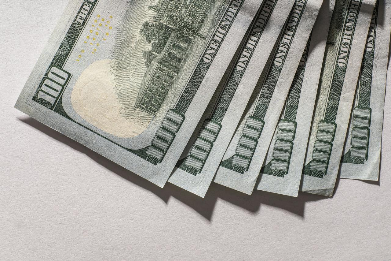 Beberapa uang kertas seratus dolar menyebar